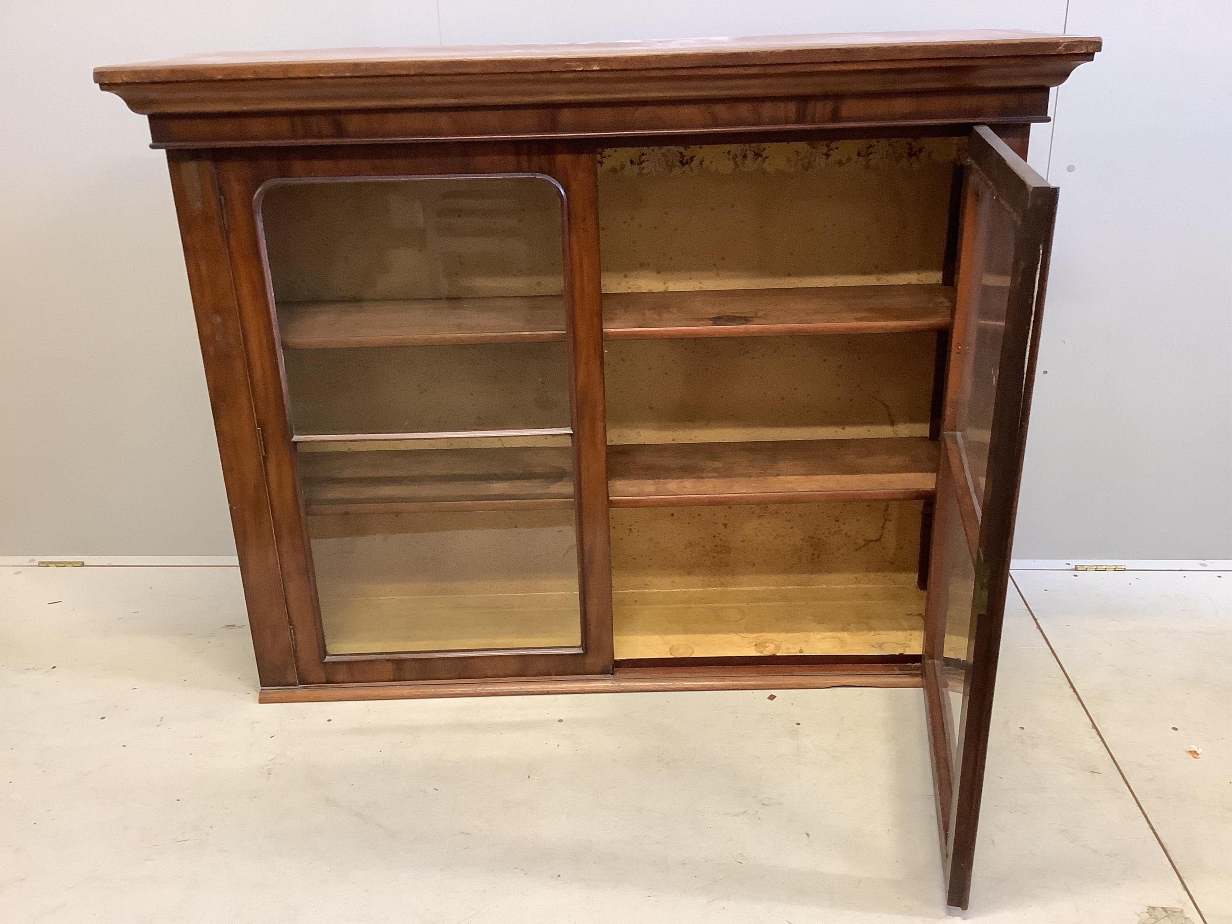 A Victorian mahogany bookcase, adapted, fitted with a pair of glazed doors, width 149cm, depth 38cm, height 116cm. Condition - fair